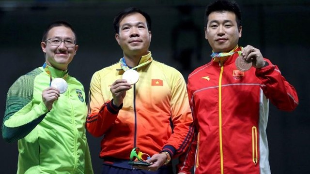 Hoàng Xuân Vinh (au milieu) avec sa médaille d’or historique. Photo: Reuters.