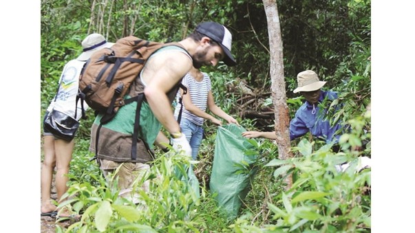 Des touristes et des jeunes collectent des déchets dans la zone touristique de Khe Rô. Photo: CVN.