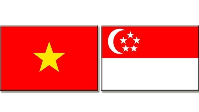 Les drapeaux du Vietnam et de Singapour. Photo: NDEL.