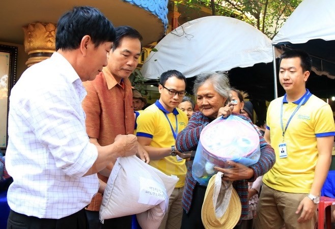 Remise des cadeaux aux Vietnamiens en situation difficile à Vientiane. Photo: VNA.