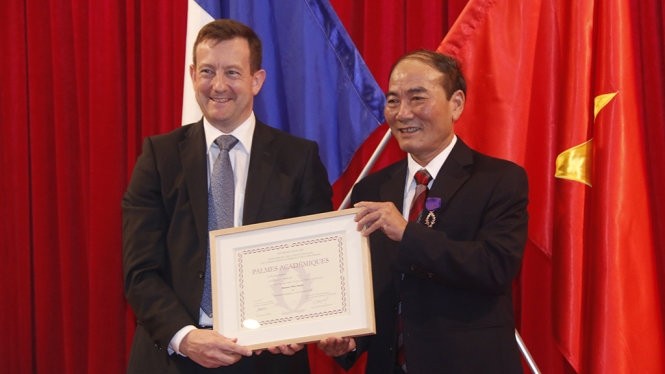 L’Ambassadeur de France au Vietnam, Bertrand Lortholary (à gauche), remet l’Ordre des Palmes Académiques à l'ancien directeur du Bureau chargé des relations extérieures et de la coopération de la ville de Huê. Photo: VNA.