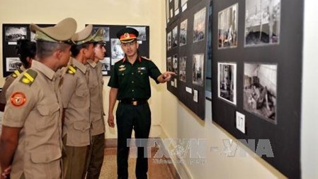 L'attaché militaire du Vietnam Vu The Trung présente des photos aux visiteurs. Photo: VNA.