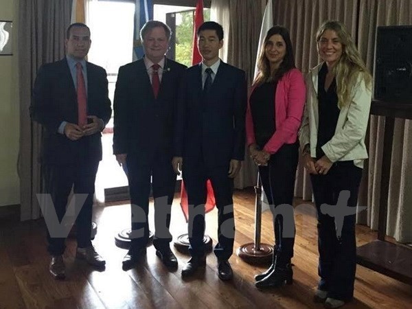 Un représentant de l’Ambassade du Vietnam en Argentine prend photo avec  d’invités. Photo: VNA.