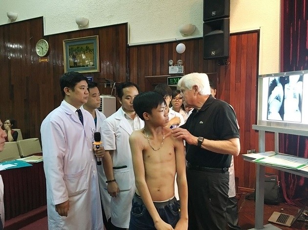 Le professeur Stuart Weinstein donne gratuitement des consultations à un enfant vietnamien ayant des scolioses à l’hôpital Viêt Duc. Photo: NDEL