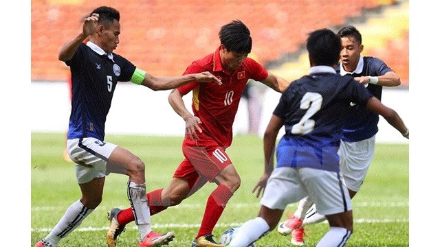 Công Phuong (maillot rouge) a ​réalisé le "coup du chapeau" durant le match ​contre le Cambodge du tournoi de football des SEA Games 29 en Malaisie. Photo: VNA.
