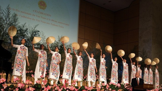 Les mannequins qui portaient des " ao dài " blancs imprimés des drapeaux des 193 pays avec les chapeaux coniques de Huê. Photo : toquoc.vn.