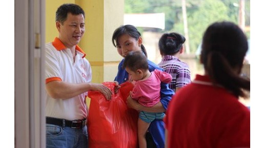 Un représentant de CARE international au Vietnam remet des produits aux habitants de Hoa Binh. Photo : VNA.