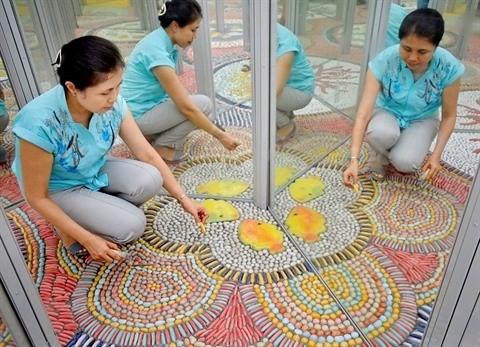 La peintre Nguyên Thu Thuy s’est passionnée pour son travail de rénovation du palais des glaces. Photo : CVN.