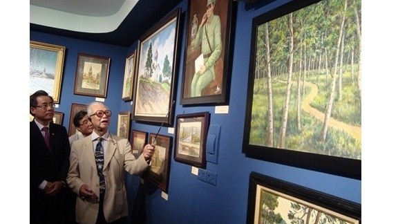 Le peintre Trân Quân Ngoc (à droite) parle de ses œuvres dans l’exposition «Les souvenirs soviétiques» qui ouvre ses portes le 7 novembre à Hanoï. Photo: CVN