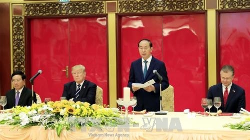 Le Président vietnamien, Trân Dai Quang (debout), et le Président américain, Donald Trump (2e à gauche), lors du banquet d'État en l'honneur de ce dernier. Photo: VNA.