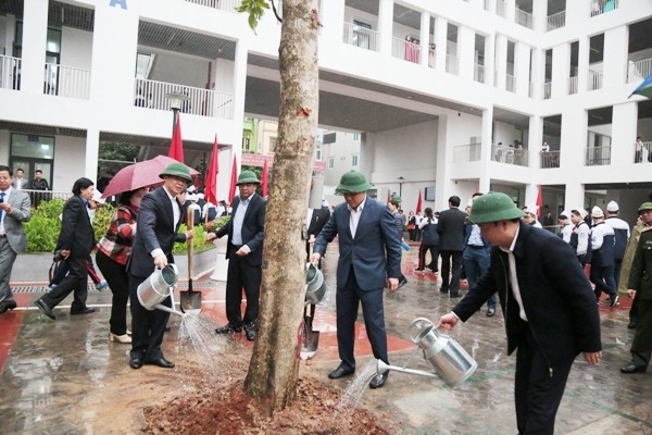 Le président du comité populaire municipal, Nguyên Duc Chung et les dirigeants de l’arrondissement de Hà Dông, plantent un arbre au collège Lê Loi. Photo : VPG
