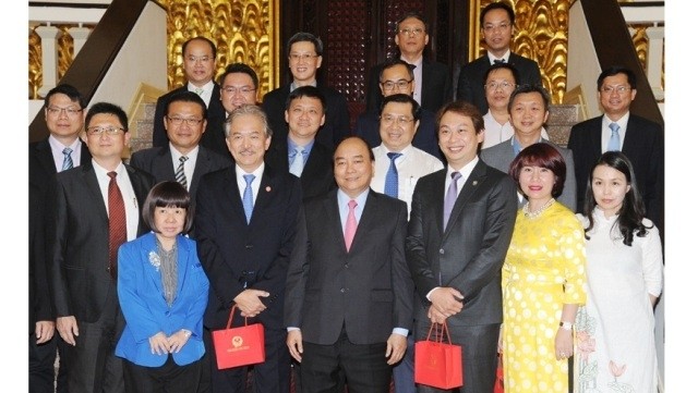 Le PM Nguyên Xuân Phuc (3e, à gauche, 1er rang) à la rencontre d’une délégation d'investisseurs singapouriens, le 6 avril à Hanoi. Photo : Trân Hai
