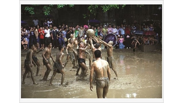 Les gens participent à la fête de lutte pour la boule en terrain boueux. Photo : VNA