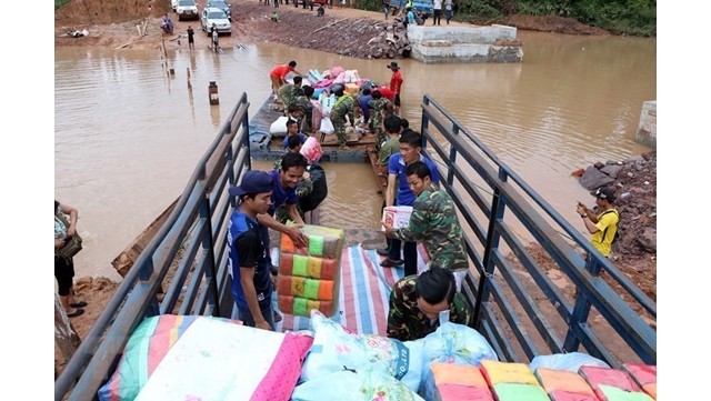 Transport d'aides en faveur des victimes de l'effondrement du barrage. Photo : VNA