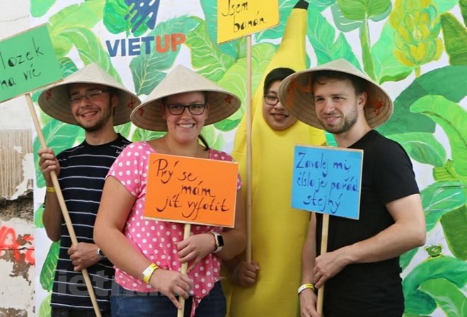 Des jeunes tchèques s'intéressent à " nón " (chapeau conique en feuilles de latanier du Vietnam). Photo : VNA.