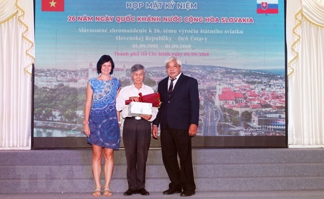 L’ambassadrice par intérim de Slovaquie au Vietnam, Ivana Belcáková, offre un bouquet de fleurs à Trân Xuân Dam, l’un des rédacteurs du Dictionnaire tchèque-vietnamien. Photo : VNA.
