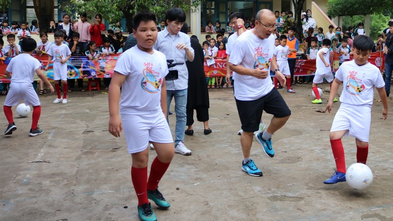 Le coach Park Hang Seo (au centre) joue au ballon avec des élèves de l’école Nhon Binh, dans la province de Binh Dinh (au Centre). Photo : PV/CVN