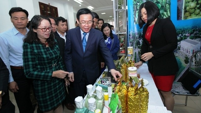  Le Vice-Premier ministre Vuong Dinh Huê en visite dans les stands présentant des produits agricoles typiques des localités. Photo : NDEL.