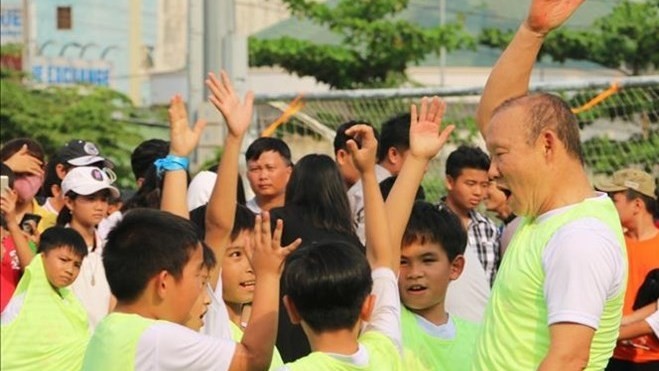 L’entraîneur Park Hang-seo (droite) et des petits mordus du ballon rond à An Giang. Photo : VNA.