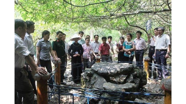 Les touristes visitent la table en pierre où l’Oncle Hô travaillait pendant des jours à Pac Bo. Photo : VGP