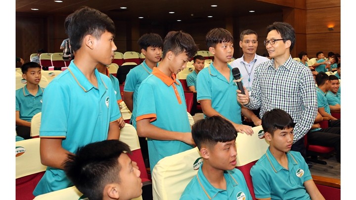 Le vice-Premier ministre Vu Duc Dam s'entretient avec des jeunes footballeurs au centre sportif Viettel. Photo : VGP.