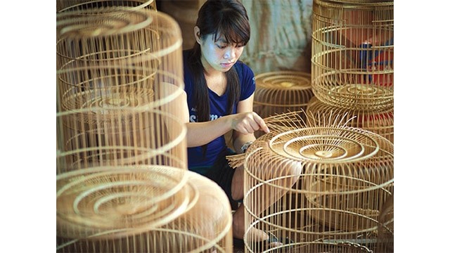 Huyên achève la dernière phase d’une cage à oiseau. Photo : http://vanhien.vn
