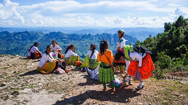 Un groupe de femmes Mông se reposent sur la route. Photo : NDEL.