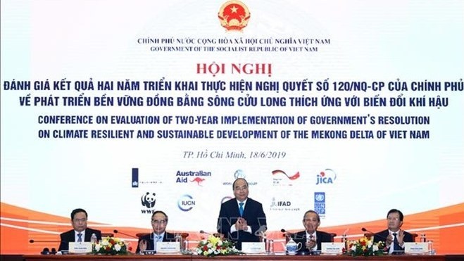 Le PM vietnamien Nguyên Xuân Phuc (debout) prend la parole lors de la conférence sur le bilan du déploiement d'une résolution sur le développement du delta du Mékong. Photo : VNA.