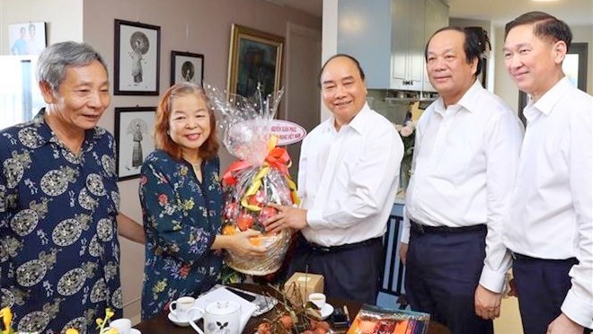Le PM Nguyên Xuân Phuc (3e à droite) offre des cadeaux à la journaliste Nguyên Thi Hang Nga. Photo : VNA.