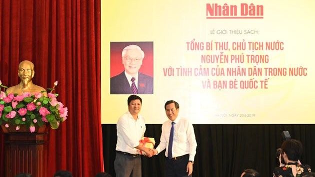 Le rédacteur en chef du Journal Nhân Dân, Thuân Huu (à droite), remet le livre au représentant du lycée Nguyên Gia Thiêu. Photo : NDEL.
