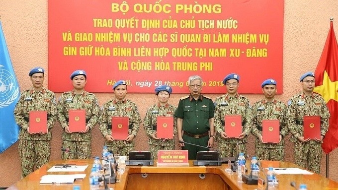 Cérémonie de remise de la décision du Président d’État à sept officiers participant aux opérations de maintien de la paix de l’ONU, le 28 juin à Hanoi. Photo : VNA.