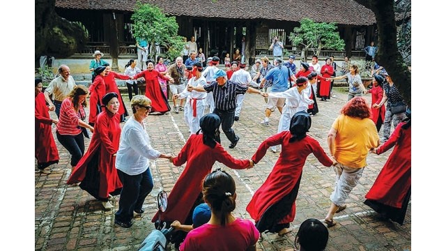 Des visiteurs participent au chant "hat xoan" à l'ancienne maison communale de Hùng Lô, à Viêt Tri. Photo : https://baoquocte.vn/ 
