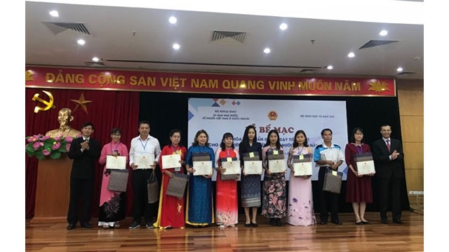 Le chef adjoint du Comité d'État chargé des Vietnamiens résidant à l'étranger, Luong Thanh Nghi, remet les certificats aux professeurs lors de la cérémonie de clôture de cette formation. Photo : VNA