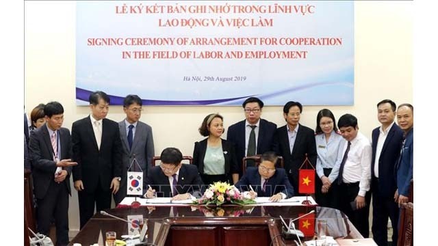 Le vice-ministre vietnamien du Travail, des Invalides de guerre et des Affaires sociales Lê Tân Dung (à droite) et le vice-ministre sud-coréen de la Santé et du Bien-être social (à gauche) signent un mémorandum de coopération dans le travail. Photo : VNA.
