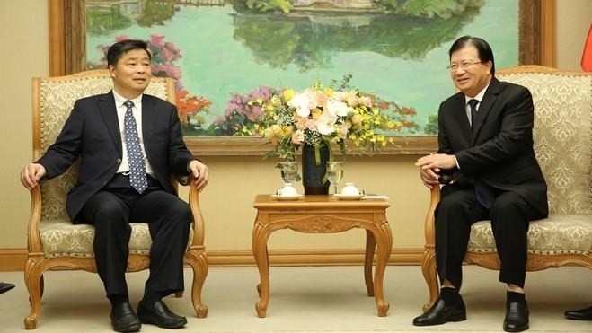 Le Vice-PM vietnamien Trinh Dinh Dung (à droite) et le vice-gouverneur de la province chinoise du Guangdong, Ouyang Weimin, le 27 août à Hanoi. Photo : VGP.