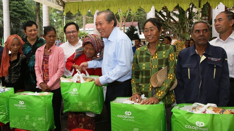 Le Vice-PM Truong Hoa Binh (au centre) remet des cadeaux à des personnes issues d'ethnies minoritaires dans le district de Lôc Ninh. Photo : VGP.