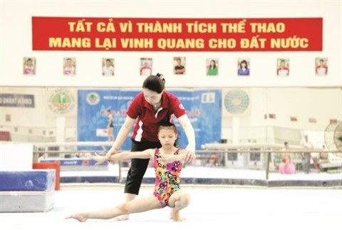 Nguyên Thi Thanh Thuy, entraîneuse de l'équipe féminine de gymnastique, et sa jeune athlète. Photo : GDTD/CVN.