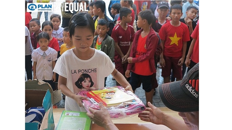 Une fille reçue de fournitures scolaires. Photo : thoidai.vn.
