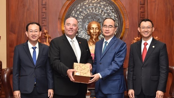 Le secrétaire du Comité du PCV pour HCM-Ville, Nguyên Thiên Nhân (2e, à droite) remet un cadeau à l'ancien ambassadeur d'Allemagne au Vietnam, Rolf Schulze. Photo: SGGP.