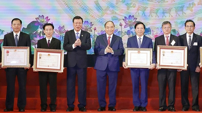 Le Premier ministre Nguyên Xuân Phuc (au centre) remet l'Ordre de l'Indépendance et l'Ordre du travail aux ministères, services, provinces, villes et organismes centraux. Photo : NDEL.