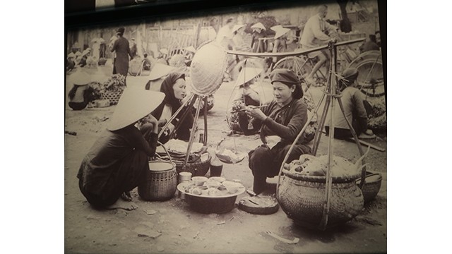 Cliché "Marchande de tiêt canh long lon (plats à base d'abats) sur un marché de Hanoi" présenté lors de l'exposition. Photo : Minh Hanh/NDEL.