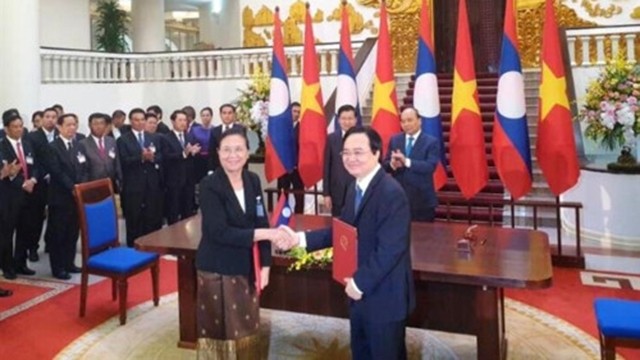 Le ministre vietnamien de l’Éducation et de la Formation Phung Xuân Nha (à droite) et la ministre laotienne de l’Éducation et du Sport Sengdeuane Lachanthaboune signent l’accord sur la coopération dans l'éducation et le développement de ressources humaines pour la période 2021-2030. Photo : giaoducthoidai.vn