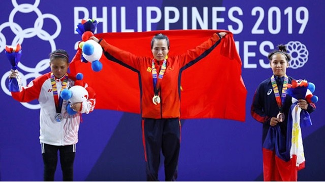 L’haltérophile Vuong Thi Huyên (au centre) décroche la médaille d’or chez les 45 kg féminin avec une levée de 172 kg. Photo : hanoimoi.com.vn.