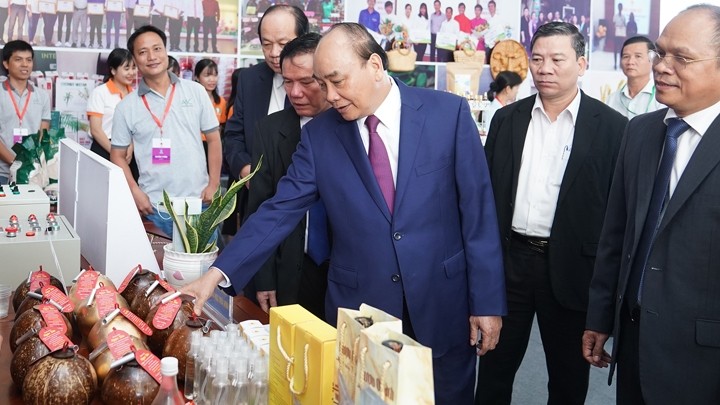 Le Premier ministre Nguyên Xuân Phuc visite les stands érigés dans le cadre de la conférence. Photo : VGP.
