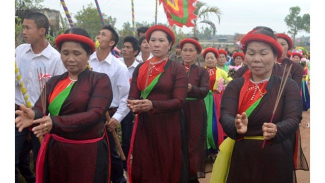 Des artisans du chant devant la maison communale donnent un numéro du chant « hat nhà to-hat, mua cua dinh ». Photo: http://www.bienphong.com.vn/