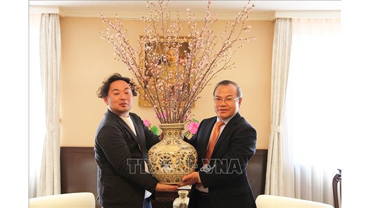 Daisuke Endo, directeur du projet «Thanks Flower» de la préfecture japonaise de Fukushima, remet des fleurs de cerisier à l'ambassadeur du Vietnam au Japon, Vu Hông Nam (droite). Photo : VNA