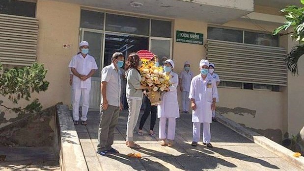 Des patients guéris offrent un bouquet de fleurs aux médecins. Photo : VNA.