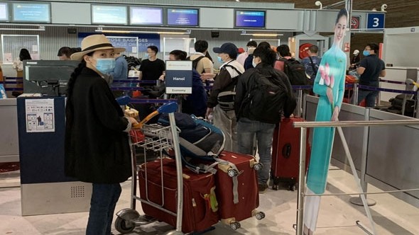 Des passagers réalisent des procédures nécessaires avant de monter à bord de l'avion. Photo : kinhtedothi.vn.