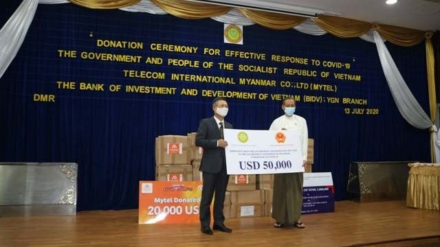 L'ambassadeur Ly Quôc Tuân (gauche) remet une somme de 50 000 dollars au représentant du gouvernement birman. Photo : VNA.