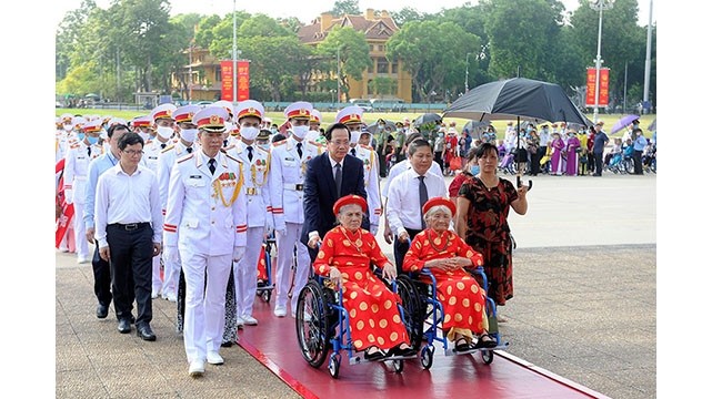 Une délégation de mères héroïques dépose une couronne de fleurs et rend hommage au Président Hô Chi Minh dans son mausolée. Photo : NDEL.